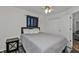 Well-lit bedroom with a full-size bed, wood-look floors, and ceiling fan at 13497 Chancellor Blvd, Port Charlotte, FL 33953