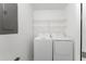 Bright laundry room with washer, dryer, and shelving at 14151 Heritage Landing Blvd # 1021, Punta Gorda, FL 33955