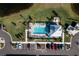Aerial view of community pool with surrounding landscaping and parking at 14151 Heritage Landing Blvd # 1021, Punta Gorda, FL 33955