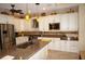 Modern kitchen with stainless steel appliances, granite countertops, and ample cabinet space at 2620 Tarpon Cove Dr # 311, Punta Gorda, FL 33950