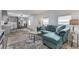 Bright living room with teal sectional sofa and wood-look floors at 6450 Floral Ct, North Port, FL 34287