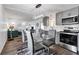 Open concept dining area with glass table and gray chairs, adjacent to kitchen at 6450 Floral Ct, North Port, FL 34287