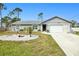 Gray house with a white garage door and a landscaped front yard at 12075 Appleberg Cir, Port Charlotte, FL 33981