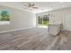 Spacious living area with wood-look floors, sliding doors, and kitchen view at 1430 Nora Ln, North Port, FL 34286