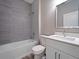 Clean bathroom with gray tile and white vanity at 1430 Nora Ln, North Port, FL 34286