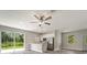 Open living room with wood-look flooring, ceiling fan, and sliding glass doors at 1430 Nora Ln, North Port, FL 34286