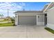 Attached gray garage with a paved driveway at 1497 Nordendale Blvd, North Port, FL 34288