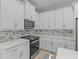 Modern kitchen featuring white cabinets, quartz countertops, and a tile backsplash at 1497 Nordendale Blvd, North Port, FL 34288