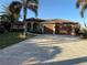 House exterior showcasing a driveway, two-car garage, and lush landscaping at 4201 Eagle Nest Ct, Port Charlotte, FL 33948