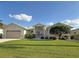 Tan house with two-car garage, lush lawn, and landscaping at 1375 Grebe Dr, Punta Gorda, FL 33950