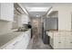 Long kitchen with white cabinets, stainless steel appliances, and a skylight at 170 Chelsea Nw Ct, Port Charlotte, FL 33952