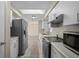 White kitchen with stainless steel appliances, a skylight, and an open view to the adjacent area at 170 Chelsea Nw Ct, Port Charlotte, FL 33952