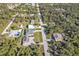 Aerial view of a residential area showing homes, roads, and lush greenery at 17152 Wintergarden Ave, Port Charlotte, FL 33948