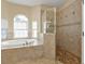Bright bathroom features a soaking tub, and a glass-enclosed shower at 17152 Wintergarden Ave, Port Charlotte, FL 33948