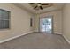 The bedroom offers a ceiling fan, carpeting, access to the lanai, and natural light from windows at 17152 Wintergarden Ave, Port Charlotte, FL 33948