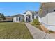 Elegant home featuring a well-manicured lawn, walkway, and decorative glass inserts in the front door at 17152 Wintergarden Ave, Port Charlotte, FL 33948