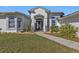 Elegant home featuring a well-manicured lawn, walkway, and decorative glass inserts in the front door at 17152 Wintergarden Ave, Port Charlotte, FL 33948