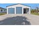 View of the exterior of the large garage with blue doors and ample parking space at 17152 Wintergarden Ave, Port Charlotte, FL 33948
