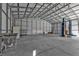 Spacious garage featuring concrete floors, overhead metal rafters, and a car lift for auto maintenance at 17152 Wintergarden Ave, Port Charlotte, FL 33948