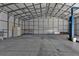 Spacious garage featuring concrete floors, overhead metal rafters, and a car lift for auto maintenance at 17152 Wintergarden Ave, Port Charlotte, FL 33948