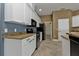 Modern kitchen features white cabinets, granite countertops, and black appliances at 17152 Wintergarden Ave, Port Charlotte, FL 33948