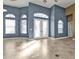 Bright living room with tile flooring, arch windows, and a decorative glass front door at 17152 Wintergarden Ave, Port Charlotte, FL 33948