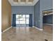 Bright living room with blue walls, large windows, and tiled floors at 17152 Wintergarden Ave, Port Charlotte, FL 33948