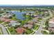 Aerial view showcasing a neighborhood with houses and a lake at 2388 Silver Palm Rd, North Port, FL 34288