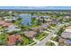 Aerial view of a tranquil neighborhood with houses and a lake at 2388 Silver Palm Rd, North Port, FL 34288