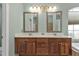 Double vanity bathroom with light colored cabinets and mirrors at 2388 Silver Palm Rd, North Port, FL 34288