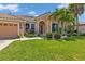 Front view of a house with a landscaped lawn and two-car garage at 2388 Silver Palm Rd, North Port, FL 34288