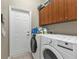 Bright laundry room with washer, dryer, and ample storage at 2388 Silver Palm Rd, North Port, FL 34288