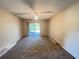 Bright bedroom featuring new carpet, a ceiling fan, and sliding glass doors to the outside at 25068 Harborview Rd # 1A, Punta Gorda, FL 33980