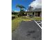 Exterior view of home, featuring a clean walkway, palm trees, and reserved parking at 25068 Harborview Rd # 1A, Punta Gorda, FL 33980