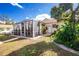 Exterior backyard view featuring a large screened lanai and lush tropical landscaping at 3646 Madagascar Ave, North Port, FL 34286