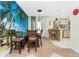 Tropical-themed dining room with a beach mural, wood table and chairs, and access to the kitchen at 3646 Madagascar Ave, North Port, FL 34286