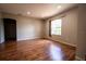 An empty room with a brown wooden floor with an arched doorway and a window at 3646 Madagascar Ave, North Port, FL 34286