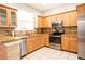 Well-lit kitchen features stainless steel appliances, tiled backsplash, tile floors, and light wood cabinets at 3646 Madagascar Ave, North Port, FL 34286