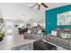 Spacious living room with gray sectional sofa, wood-look floors, and access to the dining area at 4340 Adolph Ave, North Port, FL 34288