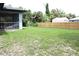 Green backyard featuring a tall wooden fence, screened-in porch, and plenty of trees for shade at 4340 Adolph Ave, North Port, FL 34288