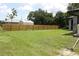 Spacious backyard with a tall wooden fence and lush grass providing privacy and room for outdoor activities at 4340 Adolph Ave, North Port, FL 34288