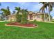 Two-story house with a manicured lawn and tropical landscaping at 15460 Longview Rd, Port Charlotte, FL 33981