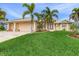 Two-story house with a two-car garage, palm trees, and lush lawn at 15460 Longview Rd, Port Charlotte, FL 33981
