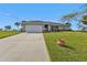 One-story home with attached garage and a spacious lawn at 36 Bunker Ln, Rotonda West, FL 33947