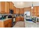 View of kitchen with granite countertops, wood cabinets, and stainless steel appliances at 4410 Turnberry Cir, North Port, FL 34288