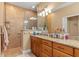 Bathroom with granite countertops, wood cabinets, and a walk-in shower at 4410 Turnberry Cir, North Port, FL 34288