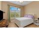Bright bedroom with tiled floors, large window, and white furniture at 4410 Turnberry Cir, North Port, FL 34288