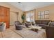 Living room with comfortable seating, coffee table, and large windows at 4410 Turnberry Cir, North Port, FL 34288