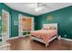 Bedroom with dark-green walls, hardwood floors, and a pink blanket at 4410 Turnberry Cir, North Port, FL 34288