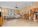 Spacious living room with L-shaped sofa, large windows, and tile flooring at 4410 Turnberry Cir, North Port, FL 34288